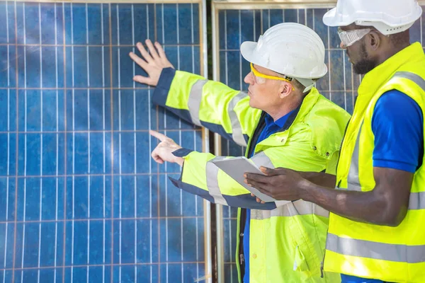 工場労働者技術者の男性は太陽電池パネルを見せてチェックする作業服とヘルメットで持続可能な技術のために コンセプト施工太陽光発電パネル再生可能エネルギー — ストック写真