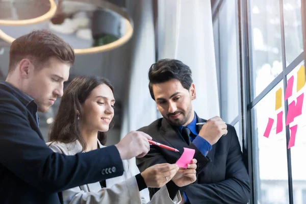 business people brainstorming putting sticky notes on glass window wall in office. Concept Creative group startup business meeting for new idea.