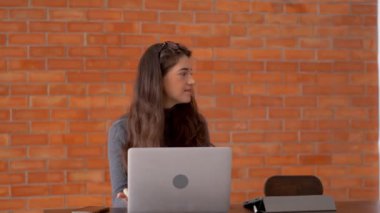 İş arkadaşına kahve veren bir adam. Ofiste birlikte çalışan iş adamları. Çalışma alanındaki kırmızı tuğlanın arkaplanı.