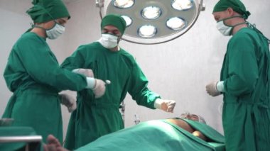 Profesyonel Cerrahlar ve Asistanı hastanedeki ameliyathanede insan göğsü ameliyatı için hazırlanıyor. Konsept doktor ve hemşire riskli yoğun bakımda çalışıyor..