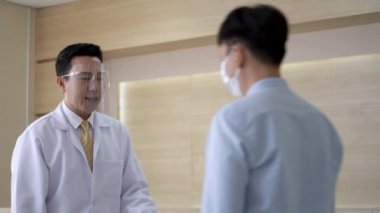 Doktor hasta sıcaklığını hastane reyonundaki insanların termal taramasını kullanarak kontrol ediyor. covid 19 ve corona virüsünden konsept koruması.