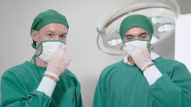 Lekarz Chirurg Uśmiecha Się Zdejmuje Medyczną Ochronę Twarzy Sali Operacyjnej — Wideo stockowe
