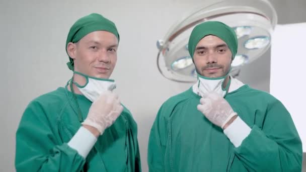 Chirurgen Behandeln Lächelnd Und Ziehen Den Medizinischen Gesichtsschutz Operationssaal Des — Stockvideo