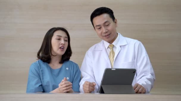 Arzt Und Medizinisches Personal Schauen Auf Ein Tablet Gerät Und — Stockvideo