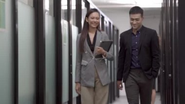 Mutlu iş adamları, akıllı gündelik hayatta kıdemli erkek ve kadın ofis koridorunda yürürken haberleri tartışıp fikir alışverişinde bulunurlar..