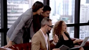 Üst düzey yönetici sunucu, modern ofiste sunumu sunuyor, dış gökdelen ile kanepe koltuğunda oturuyor, hoparlör hocası profesyonel takımı anlatıyor..