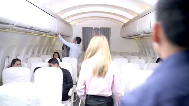 乗客が座席に歩いて荷物を保管している飛行機の内部 離陸前に — ストック動画