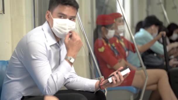 마스크를 남자는 스마트폰을 사용하고 지하철에서 대중교통을 이용하는 사람들과 있습니다 코로나 — 비디오
