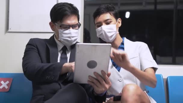 在地铁的公共交通工具上 商人使用智能平板电脑 与戴面具的女士在一起 带有大流行性流感的新生命概念 结肠病毒或弧菌19 — 图库视频影像