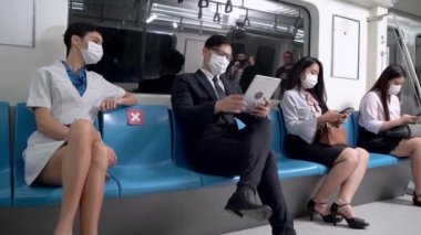 İş adamı akıllı tablet kullanıyor ve metro metrosunda maske takan bir kadınla buluşuyor. Salgın Grip Coronavirüsü ya da covid 19 ile yeni bir yaşam kavramı.