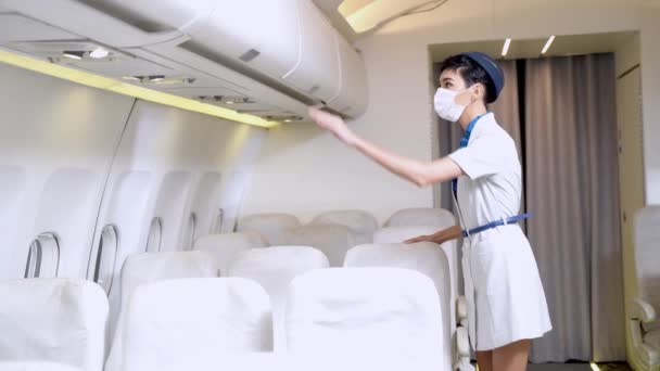 Kvinnlig Flygvärdinna Eller Kabinbesättning Med Ansiktsmask Täcker Munnen Kontrollerar Passagerarsäten — Stockvideo