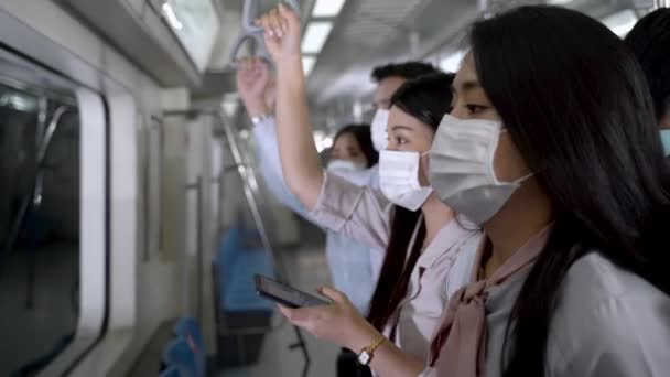 마스크를 여성은 스마트폰 기기를 사용하며 대중교통을 이용하는 사람들과 지하철에 코로나 — 비디오