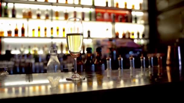 背景にカクテルバー棚付きカウンターテーブルの上のワイングラス — ストック動画