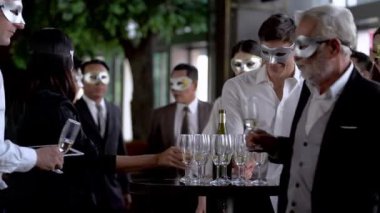 Parti maskeli yöneticileri kutlamak için içki bardağını kaldırıyor ve konuşuyor. Çeşitli iş adamları, şirket ya da festival etkinliğinin başarısını kutlamak için parti veriyor..