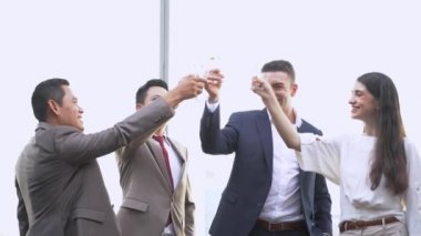 Bir grup başarılı yönetici iş adamı kutlama için içiyor ve konuşuyor. Çeşitli iş adamları açık havada gökdelende parti yaparlar..