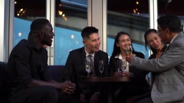 Bir grup heyecanlı iş adamı oturup bir bardak şarapla kutlama yapıyor ve başarılarına kadeh kaldırıyor. Asyalıların buluşması ve konuşması komik ve mutlu hissettiriyor..