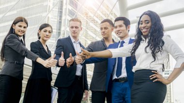 İş adamlarından oluşan bir ekip zeki bir adam ve bir kadın yaya geçidinde el ele tutuşuyorlar..