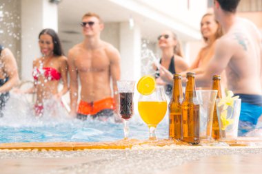 içecek şişesi bira ve egzotik kokteyller ellerinde seksi komik vücutlar yüzme havuzundaki insanlar.