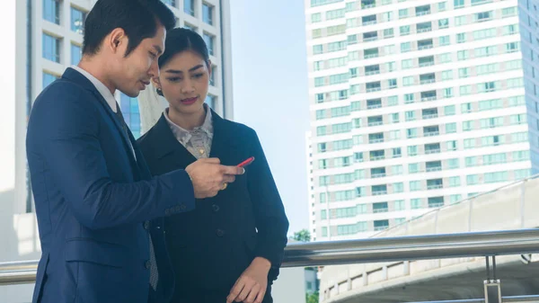 在户外用智能手机在网上听到好消息的兴奋的男女商人 — 图库照片