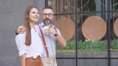 Üst düzey bir adam ve kadın bina duvarında yürüyorlar..