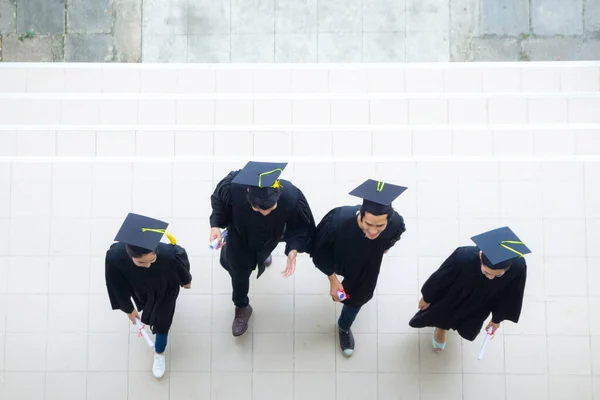 학생들이 가운을 고전적 건물의 복도에서 모자를 채걷는 — 스톡 사진