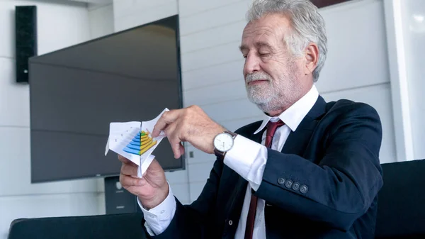 Portrait happy senior businessman relax and folding paper plane from document file graph in office.