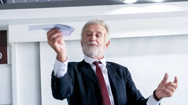 Portrait happy senior businessman relax and folding paper plane from document file graph in office.