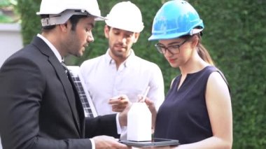 Mühendis ve iş adamı inşaat modelini planlıyor. Yenilikçi Güneş Paneli Bataryası Yenilenebilir Enerji Çalışması Kavramı ile Buluşma. Dış mekanda fotovoltaik hücre modülü testleri için toplanan uzmanlar.