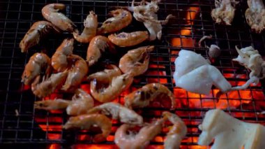 Ateş ve dumanlı taze deniz karidesi ızgarası. Barbekü işleminde deniz ürünleri barı ve ızgara kavramı.