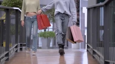 Güzel genç Asyalı kadınlar birlikte alışveriş yapıyorlar.