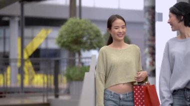 Güzel genç Asyalı kadınlar birlikte alışveriş yapıyorlar.