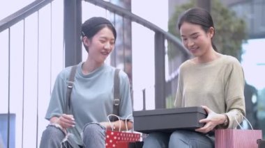 Güzel genç Asyalı kadınlar birlikte alışveriş yapıyorlar.