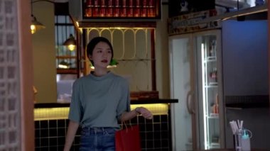 Hafta sonu genç Asyalı bir kadının çantalarla alışveriş yaptığı görüntüler.