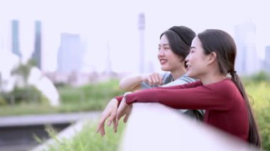 Güzel genç Asyalı kadınlar parkta birlikte vakit geçiriyorlar.