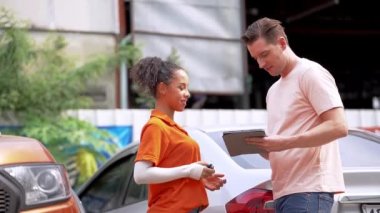 Otomobil servisi kadın çalışanı. Depoda tamirat için araba aldığı için müşteriye anahtar veriyor. Yedek parça taşımacılığı endüstrisinde çalışan insanları kavrayın.