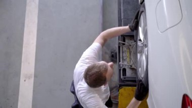 Fabrika elbiseli, araba tamircisi ve garaj otoparkını tamir eden işçilerin üst düzey görüntüsü. Yedek parça taşımacılığının endüstriyel deposunda çalışanlar.