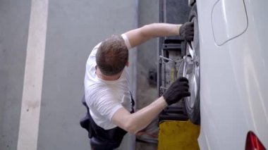 Fabrika elbiseli, araba tamircisi ve garaj otoparkını tamir eden işçilerin üst düzey görüntüsü. Yedek parça taşımacılığının endüstriyel deposunda çalışanlar.