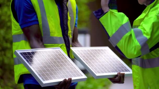 工場労働者技術者の男性は太陽電池パネルを見せてチェックする作業服とヘルメットで持続可能な技術のために コンセプト施工太陽光発電パネル再生可能エネルギー — ストック動画
