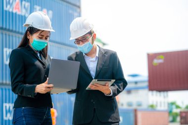 Erkek kadın mühendislerin ve işçilerin tablet aygıt kullanarak konteynır ve kargo alanının önünde buluşmalarının portresi. Nakliye sektöründe çalışan kendinden emin ve zeki iş adamları..