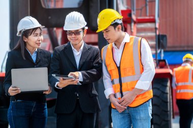 Erkek mühendis ve işçilerin tablet dizüstü bilgisayar kullanarak konteynır ve kargo önünde buluşmalarının portresi. Nakliye sektöründe çalışan kendinden emin ve zeki iş adamları..