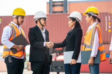Mühendisler ve işçiler konteynır ve kargo alanının önünde el sıkışıyor ve buluşuyorlar.