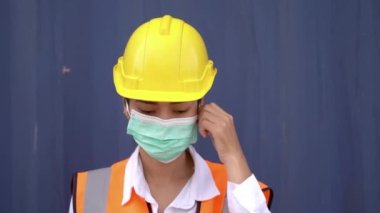 Asyalı fabrika işçisi kadın maskesini çıkarıyor. Toz ve hava kirliliğini korumak için güvenlik maskesi takan insanlar. Virüs enfeksiyonunu önlemek için yüz maskesi COVID 19 ve korona virüsü.