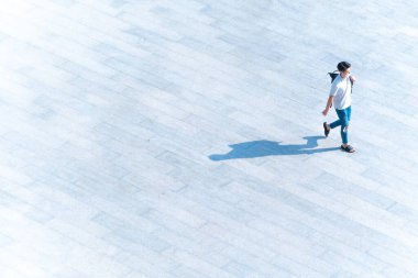 Yüzü maskeli üst düzey insanlar, zeminde siyah gölgesi olan yaya betonunda yürüyorlar. Toplumsal yeni normal yaşam konsepti, covid salgını ve hava kirliliğini önleme..