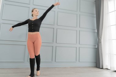 Stüdyodaki kadın balerin portresi. Çağdaş dans sanatçısı. Klasik bale eğitimi aldım. Güzel zarif balerin duvar ve pencere lambasında bale pratiği yapıyor..