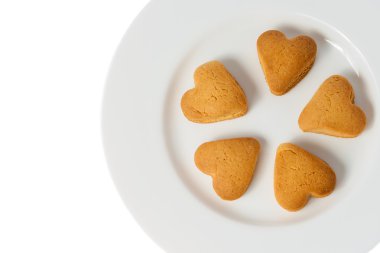 Çerezler bir kalp şeklinde beyaz bir plaka üzerinde