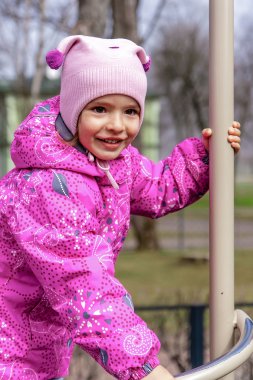 Küçük mutlu kız çocuk oyun alanında oynuyor.