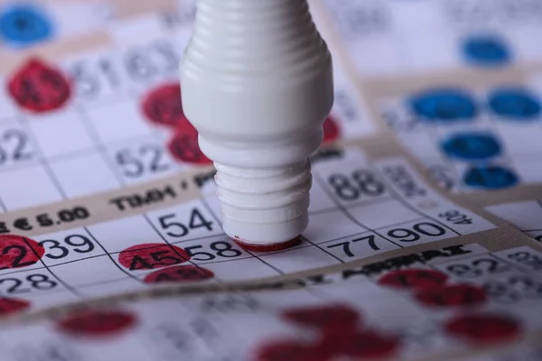 Playing Bingo. Marking numbers with red marker