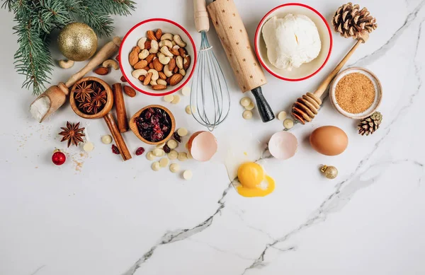 Christmas - baking cake background. Dough ingredients and decorations on white marble table. Kitchen layout with free text space. Top view. Flat lay