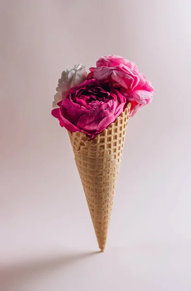 Flowers in a waffle cone on beige background. Selective focus with copy space