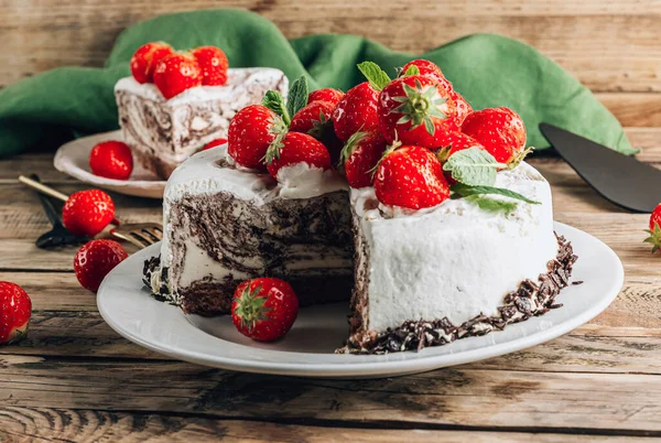 Chocolate zebra mousse cake with strawberry over wooden rustic background.